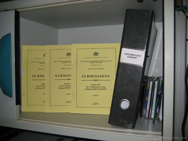 Bookshelf containing the 1998 Parliamentary Enquiry volumes on the sinking of HMAS Sydney.